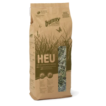 Braune Papiertüte mit Kaninchenheu, beschriftet mit 'HEU', mit einem transparenten Fenster, das das Heu im Inneren zeigt, mit einem Design aus grünem Gras und Schmetterlingen.