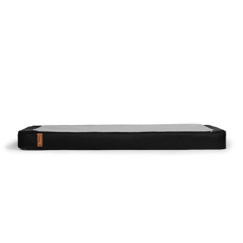 Schwarzes Haustierbett mit einer grauen Oberflächenstruktur, mit einem kleinen braunen Etikett an der Seite.