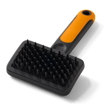 Schwarze Gummibürste zur Fellpflege mit kurzen konischen Noppen und orange-schwarzem ergonomischem Griff.