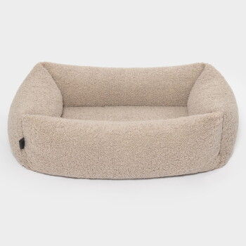 Ein gemütliches beiges Haustierbett mit weichem, flauschigem Stoff und erhöhten Rändern, perfekt für kleine bis mittelgroße Haustiere.