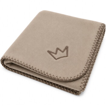 Gefaltete beige, wildlederähnliche Hundedecke mit aufgesticktem Kronenlogo und Zickzack‑Whipstich‑Kante.