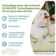 Weißer flauschiger Hund, der einen WHIMZEES-Zahnpflegesnack auf einem grünen Bett kaut; deutscher Text: 'WHIMZEES Zahnpflegesnacks'.