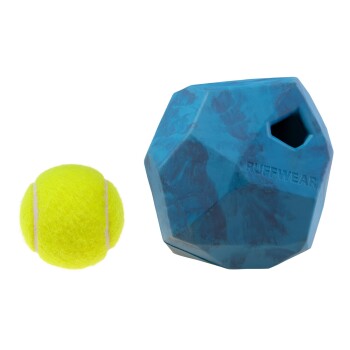 Ein leuchtend gelber Tennisball neben einem blauen, geometrisch geformten Hundespielzeug mit der Aufschrift "RUFFWEAR."