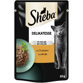 Sheba Delikatesse Katzenfutterbeutel mit einer grauen Katze und einer Schüssel mit Fleisch in Gelee, beschriftet mit "mit Truthahn à la dinde," 85g.