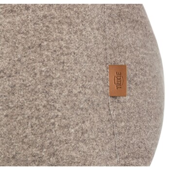 Nahaufnahme eines weichen, grauen Haustierbettes mit einem kleinen braunen Lederetikett, das mit dem Markennamen "Trixie" geprägt ist.