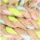 Nahaufnahme eines bunten geflochtenen Haustierspielzeugs aus natürlichen Fasern, mit leuchtend pinken, grünen und blauen Akzenten.
