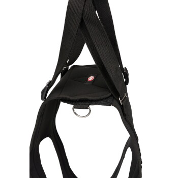 Black padded dog harness with wide adjustable straps, metal D-ring and red logo patch with white text.