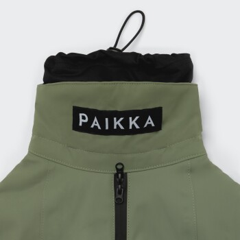 Grüne und schwarze Haustierjacke mit Reißverschluss und „PAIKKA“-Etikett am Kragen, für den Außeneinsatz konzipiert.