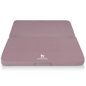 Ein gefaltetes Hundebett in sanftem Lavendel mit einem weißen 'KNUFFELWUFF'-Logo auf der Vorderseite, mit einem einfachen, modernen Design.