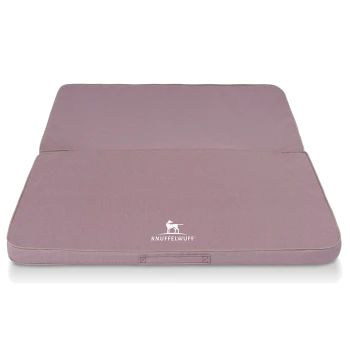 Ein gefaltetes Hundebett in sanftem Lavendel mit einem weißen 'KNUFFELWUFF'-Logo auf der Vorderseite, mit einem einfachen, modernen Design.
