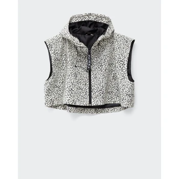 Eine ärmellose Kapuzenweste mit einem schwarz-weißen gepunkteten Muster, mit einem Frontreißverschluss und einem Etikett, auf dem "PAKKA" steht.