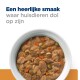 Een kom huisdierenvoer met stukjes vlees, groenten en jus, met de tekst 'Een heerlijke smaak waar huisdieren dol op zijn' erboven.