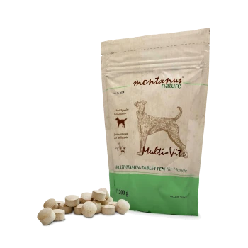 Eine Tüte montanus nature Multi-Vit Multivitamin-Tabletten für Hunde, mit einer Hundegrafik auf der Vorderseite, umgeben von mehreren Tabletten.