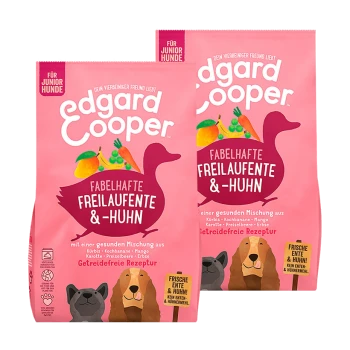 Deux sacs de nourriture pour chiens sans céréales Edgard Cooper pour juniors, avec un fond rose et des illustrations de légumes et d'un canard.