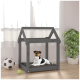Ein schwarz-weißer Hund ruht auf einem grauen Haustierbett in einem hölzernen Hundehäuschen, mit einem Fußball und einem Tennisball in der Nähe.