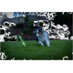 Australian Shepherd Hund spielt mit einem grün leuchtenden Stock auf Gras in einem Garten bei Dämmerung.