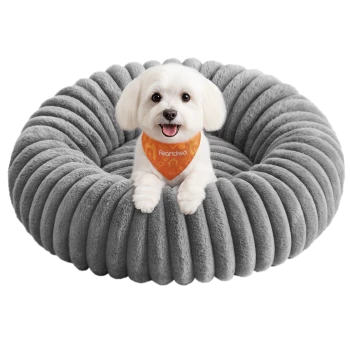 Kleiner weißer Hund trägt ein orangefarbenes Feandrea-Bandana und liegt in einem runden, grauen, plüschigen Haustierbett.