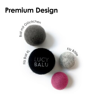 Vier Filzbälle (dunkelgrau, schwarz, hellgrau, rosa) vor weißem Hintergrund mit dem Text 'Premium Design' und schwarzem Ball mit Stickerei 'LUCY BALU'.