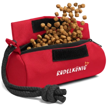 Rote Tiernahrungsbeutel mit dem Text "RUDELKÖNIG", der Futter auf einen weißen Hintergrund verschüttet.