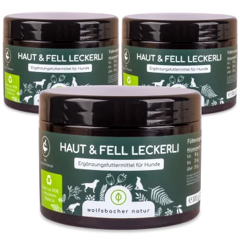 Drei Gläser "Haut & Fell Leckerli", ein Hundefutterergänzungsmittel, mit einem dunkelgrünen Etikett mit weißem Text und Illustrationen von Tieren und Pflanzen.