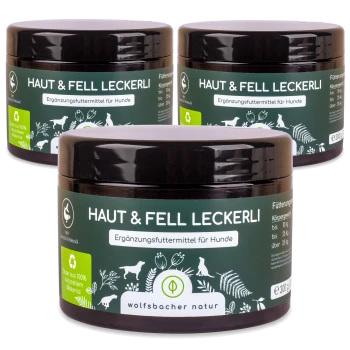 Drei Gläser "Haut & Fell Leckerli", ein Hundefutterergänzungsmittel, mit einem dunkelgrünen Etikett mit weißem Text und Illustrationen von Tieren und Pflanzen.