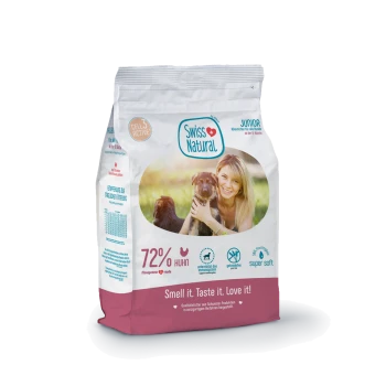 Tüte Swiss Natural Junior Tierfutter, weiß-pinke Verpackung mit Aufdruck "72% Huhn" und Slogan "Riech es. Schmeck es. Lieb es!"