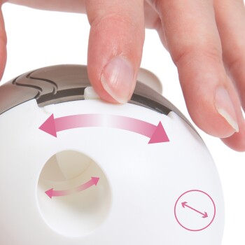 Gros plan d'une main ajustant un jouet interactif pour animaux de compagnie blanc et brun, avec des flèches indiquant les directions de mouvement.