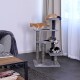 Drei verspielte Kätzchen, eines orange und zwei schwarz-weiß, erkunden einen mehrstöckigen Kratzbaum in einem gemütlichen Wohnzimmer.
