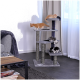 Drei verspielte Kätzchen, eines orange und zwei schwarz-weiß, erkunden einen mehrstöckigen Kratzbaum in einem gemütlichen Wohnzimmer.