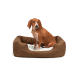 Ein braunes Hundebett mit einem weichen weißen Innenraum, mit einem sitzenden braunen Hund mit weißen Flecken, der bequem und entspannt aussieht.