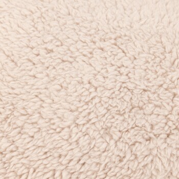 Nahaufnahme eines weichen, beigen Haustierbettstoffs mit flauschiger Textur, ideal für den Komfort von Haustieren.