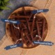 Ein Holzbrett hält dunkelbraune Haustierleckereien, die auf Deutsch beschriftet sind: 'sehr mager', 'leicht', 'lecker' und 'hocharomatisch.'