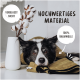 Ein schwarz-weißer Hund liegt auf einer grünen Decke neben einer weißen Vase mit Baumwollzweigen. Text: "Hochwertiges Material," "100% Baumwolle."