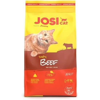 Ein gelber und roter Katzenfutterbeutel mit einer verspielten orangefarbenen getigerten Katze, beschriftet mit "JOSI CAT Tasty Beef," mit "ADULT" und "1.9 kg" deutlich sichtbar.