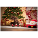 Ein verspielter brauner Welpe mit einem Lebkuchenmann-Spielzeug ist von festlichen Dekorationen umgeben, darunter ein Weihnachtsbaum und Weihnachtsmannfiguren.