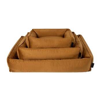 Ein Stapel von drei plüschigen, rechteckigen Haustierbetten in einem warmen Braunton, mit weichem Stoff und schwarzen Etiketten an den Seiten.
