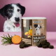 Dose mit der Aufschrift 'Tierliebhaber Analdrüsen Drops' mit dunklen runden Leckerlis, Süßkartoffel, Rosmarinzweig und Hund im Hintergrund.