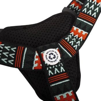 Nahaufnahme eines schwarzen Haustiergeschirrs mit bunten geometrischen Mustern und einem Logo mit der Aufschrift "Recycled Gear for Pet Loving."