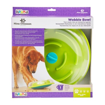 Ein Golden Retriever interagiert mit einem grünen Wobble Bowl Spielzeug von Nina Ottosson, das darauf ausgelegt ist, die Mahlzeit zu einem spannenden Spiel zu machen.