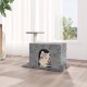 Ein gemütliches graues Katzenhaus mit einem Bogen, in dem eine entspannte getigerte Katze herausspäht, in einem hellen Raum mit großen Fenstern.