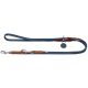 Eine blaue Hundeleine mit braunen Lederakzenten und einem Metallclip, mit einem Schlaufenhandgriff und einem kleinen Etikett.