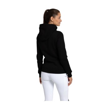 Eine Frau in einem schwarzen Hoodie und weißen Hosen, von hinten gesehen, die das Design und die Passform des Hoodies zeigt.
