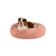 Ein glücklicher Australian Shepherd Hund, der in einem weichen, runden, rosa Haustierbett mit herausgestreckter Zunge entspannt und bequem aussieht.