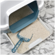 Eine Katzenstreu-Box mit einem hellen, sandigen Substrat und einer blauen Schaufel, die auf dem Tablett ruht, vor einem marmorierten Hintergrund.
