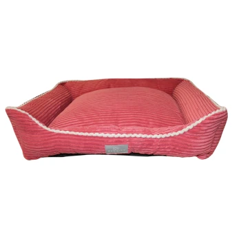 A plush, pink pet bed with a ribbed texture and white braided trim, featuring a small label that reads "Beddies."