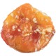 A close-up of a chewy, round pet treat with a glossy, orange-red surface and sprinkled with white sesame seeds.