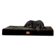 Ein schwarzer und brauner Dobermann, der auf einem plüschigen Hundebett mit einer strukturierten grauen Oberseite und einer schwarzen Seite liegt, mit einem kleinen Logo-Patch.