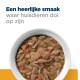 Een witte kom met huisdierenvoer met vlees, erwten, wortelen, en rijst, getopt met de tekst 'Een heerlijke smaak waar huisdieren dol op zijn.'