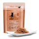 Ein 300g Beutel Catz Finefood, beschriftet mit "N° 25", mit Huhn und Thunfisch, neben einem weißen Teller mit Nassfutter für Katzen präsentiert.