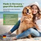Eine Frau sitzt am Strand mit einem Golden Retriever und bewirbt in Deutschland hergestellte Tierprodukte, mit Häkchen für Qualitätsstandards.